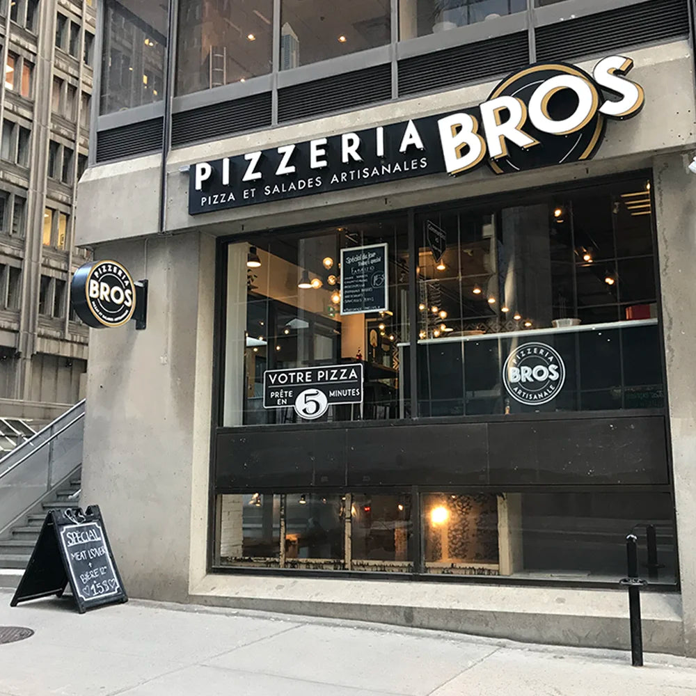 La façade d'une succursale Pizzeria Bros sur une rue du centre-ville